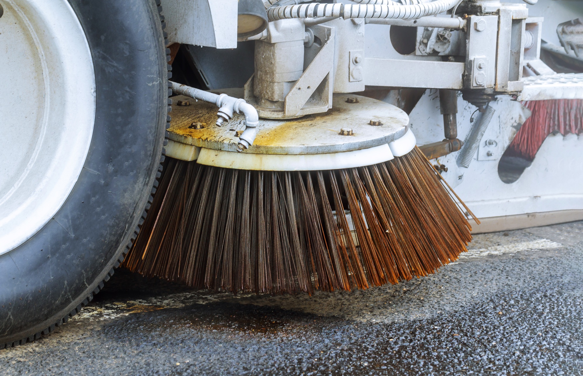 Machine car cleaning the road detail of a street sweeper in the process of cleaning the street