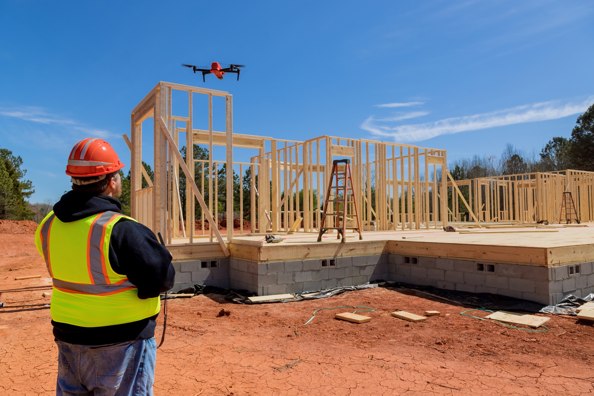 The inspector controls the unfinished construction works of the new house with the help of a drone